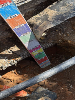 Utility survey depth indication beside an excavation
